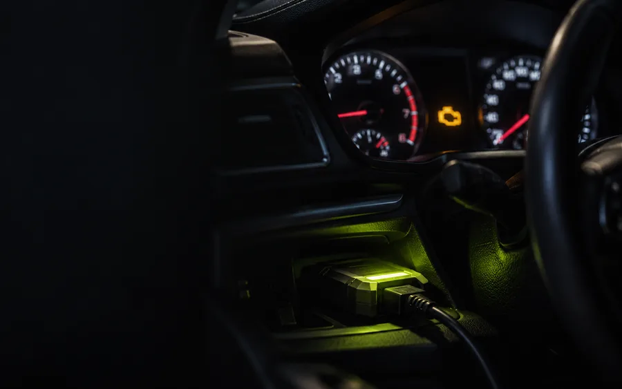 An instrument cluster at night with the check engine lamp lit